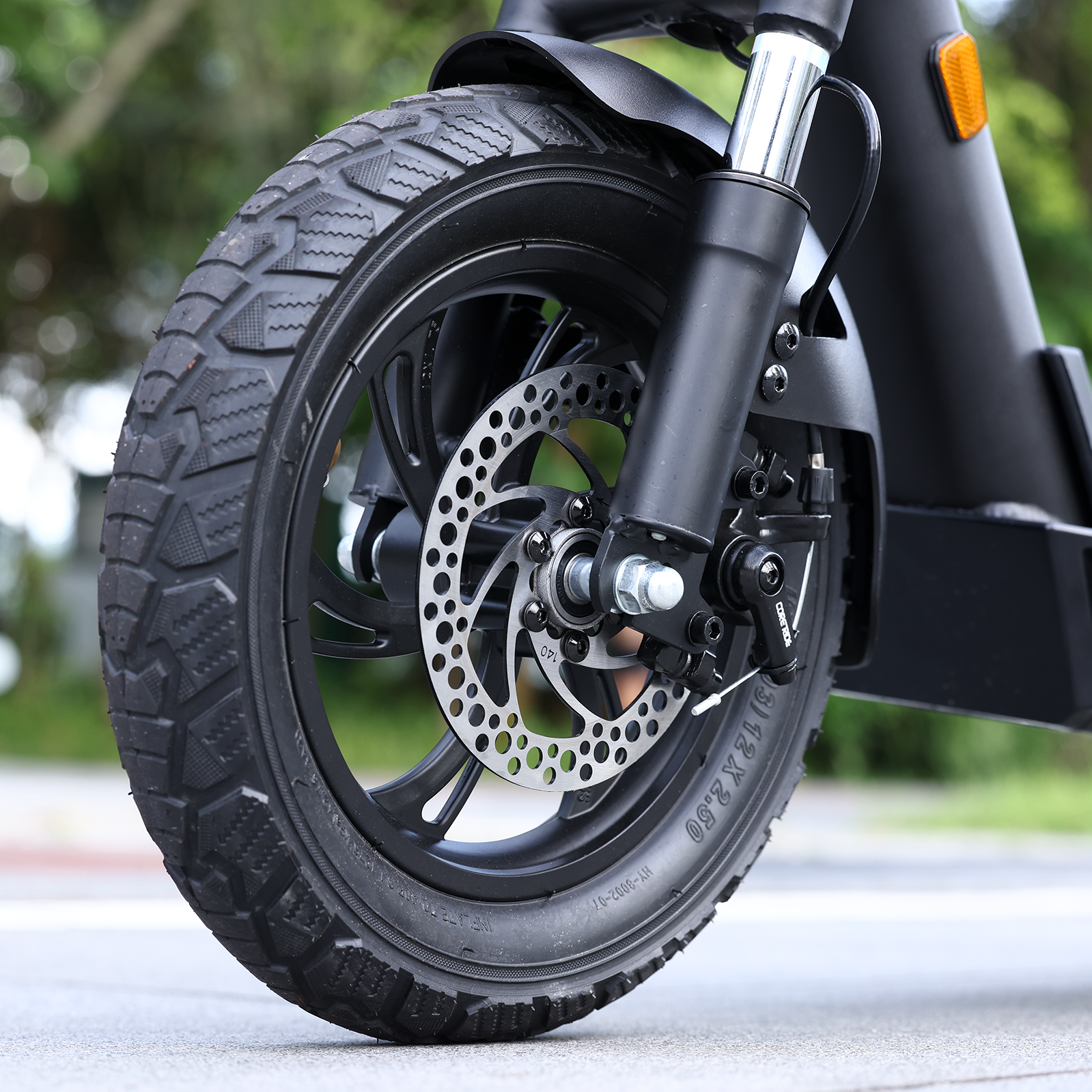 Close-up of the Hiboy X300's 12-inch pneumatic tire, disc brake and telescopic front fork
