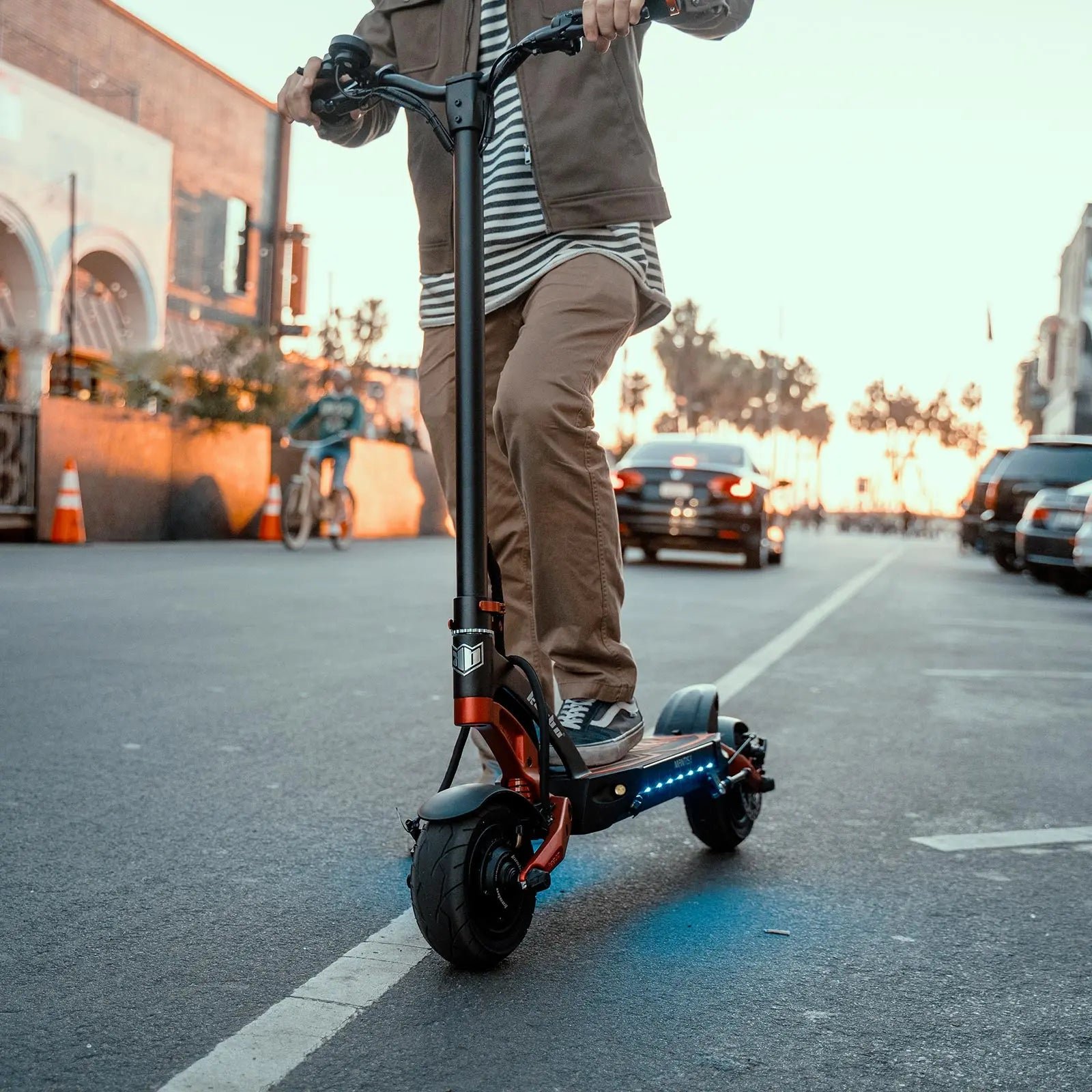 Commuter riding the Kaabo Mantis 8 Lite electric scooter through the city