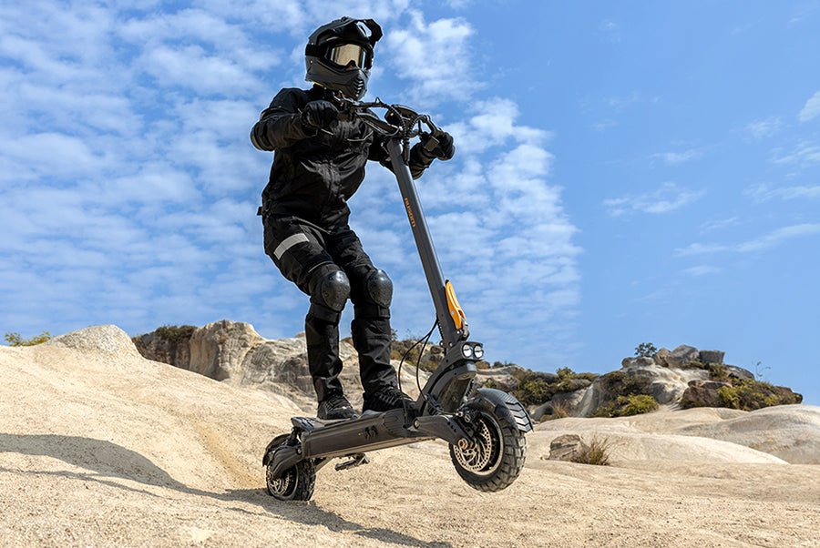 Rider in full protective gear jumping the Ausom F1 Max electric scooter off a sandstone ledge