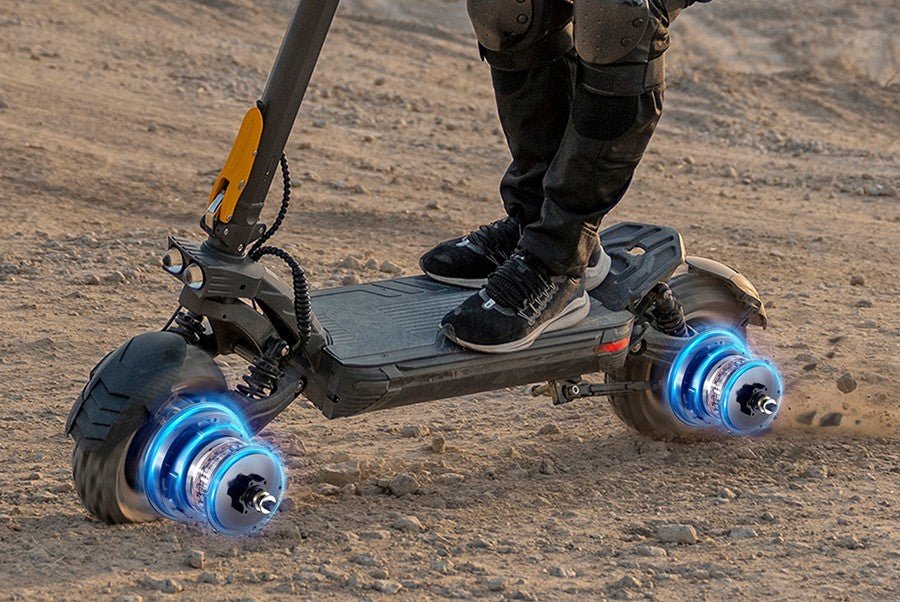 Both hub motors of the Ausom F1 Max electric scooter glowing as it accelerates across packed dirt