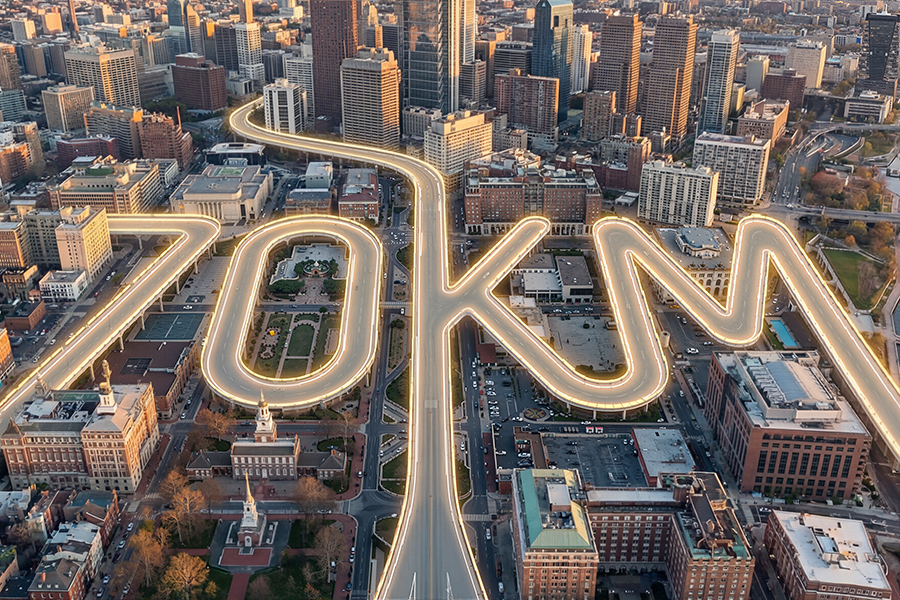Aerial city view with an illuminated route tracing 70 kilometers of road, Ausom's range artwork for the Gosoul 2 electric scooter