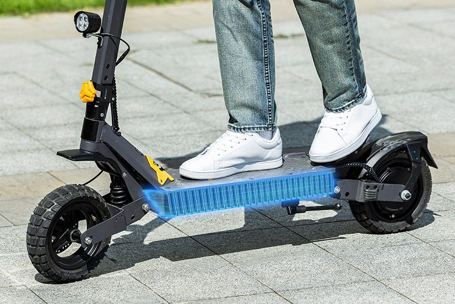 Ausom L1 electric scooter ridden across a plaza with its battery pack illustrated glowing through the deck