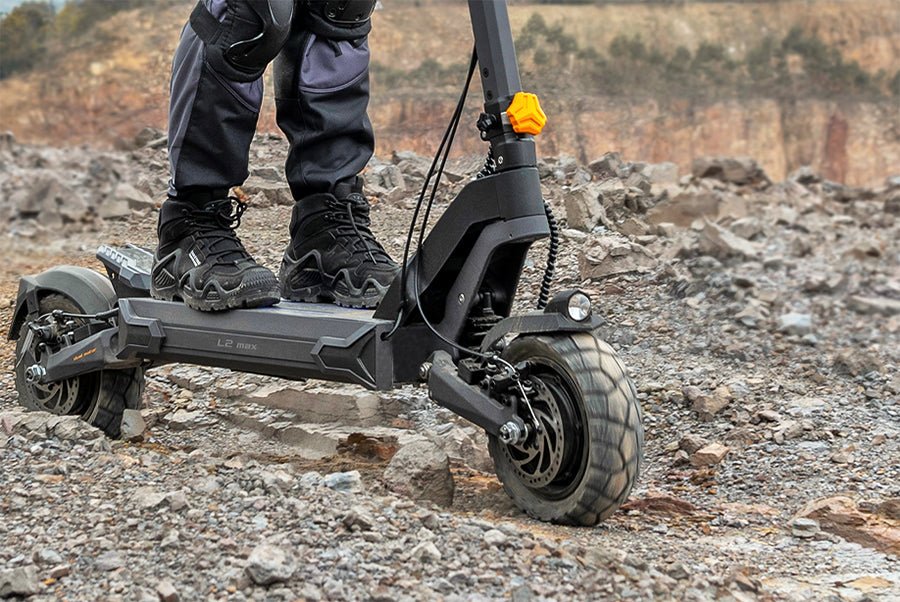 Deep-tread front tire of the Ausom L2 Max dual motor e-scooter gripping loose rocky ground
