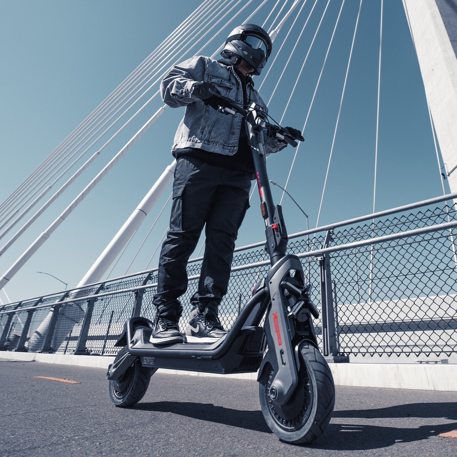 Rider crossing a suspension bridge on a Segway GT3 SuperScooter in daylight