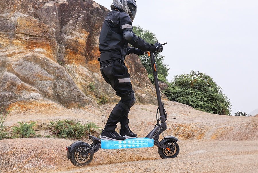 Ausom SR1 electric scooter ridden across rocky terrain with its battery pack illustrated glowing in the deck