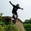 Rider jumping an INMOTION V14 PRO electric unicycle off a boulder