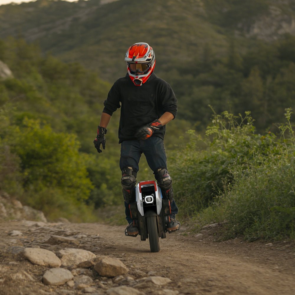 Rider climbing a rocky trail on an INMOTION V14 PRO electric unicycle