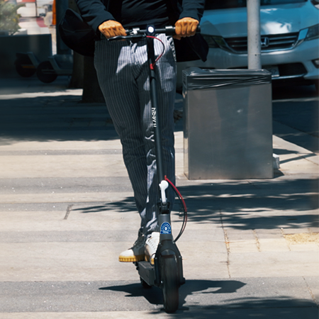 Rider on the Hiboy S3 electric scooter crossing a city street