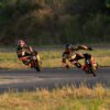Two INMOTION P6 electric unicycle riders leaning through a sunset corner