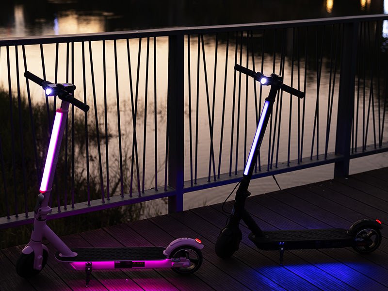 Pink and black Hiboy S2 Lite electric scooters at dusk with stem lights and deck lights glowing