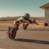 Rider leaning an INMOTION P6 electric unicycle hard through a desert circuit