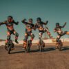 Four riders posing on INMOTION P6 electric unicycles in the desert