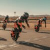 Three INMOTION P6 electric unicycle riders on a desert airfield