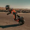 Rider carving an INMOTION P6 electric unicycle past a tyre wall