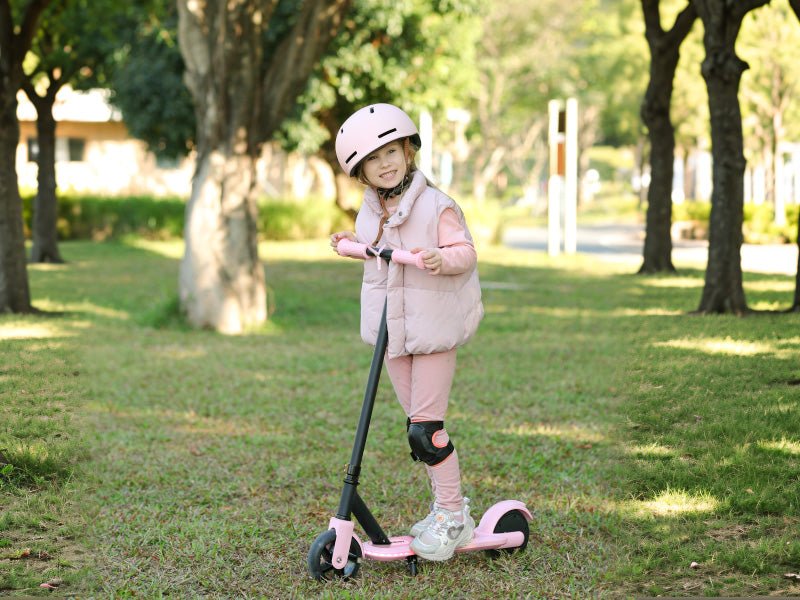 Child in a pink helmet holding the silicone grips of a pink Hiboy ES1 kids electric scooter