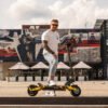 Rider standing with the Teverun Blade Mini Ultra electric scooter in a city square