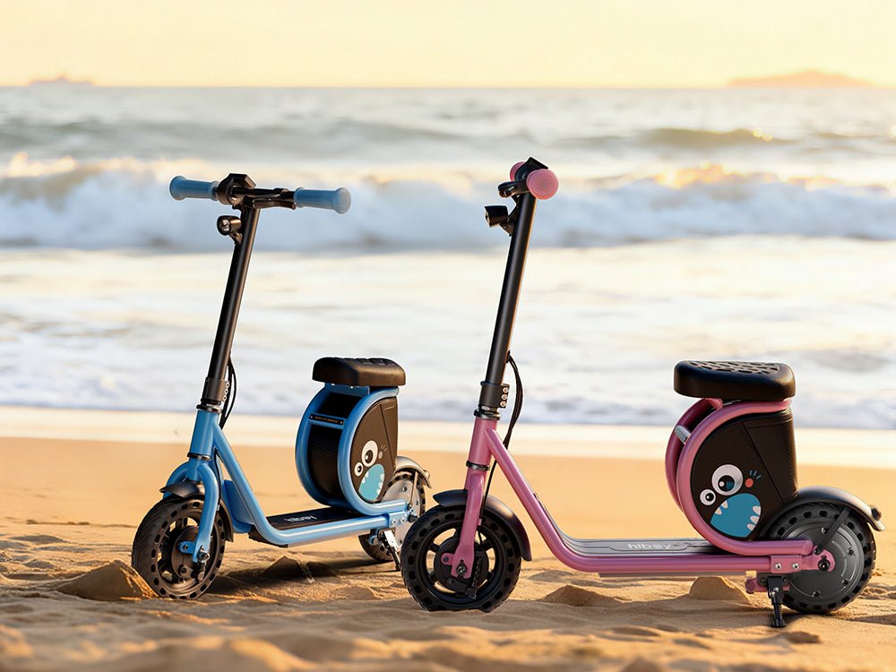 Blue and pink Hiboy Joy Haul kids electric scooters on a beach at sunset