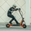 Rider leaning hard on an INMOTION RS Lite electric scooter beside a tiled wall