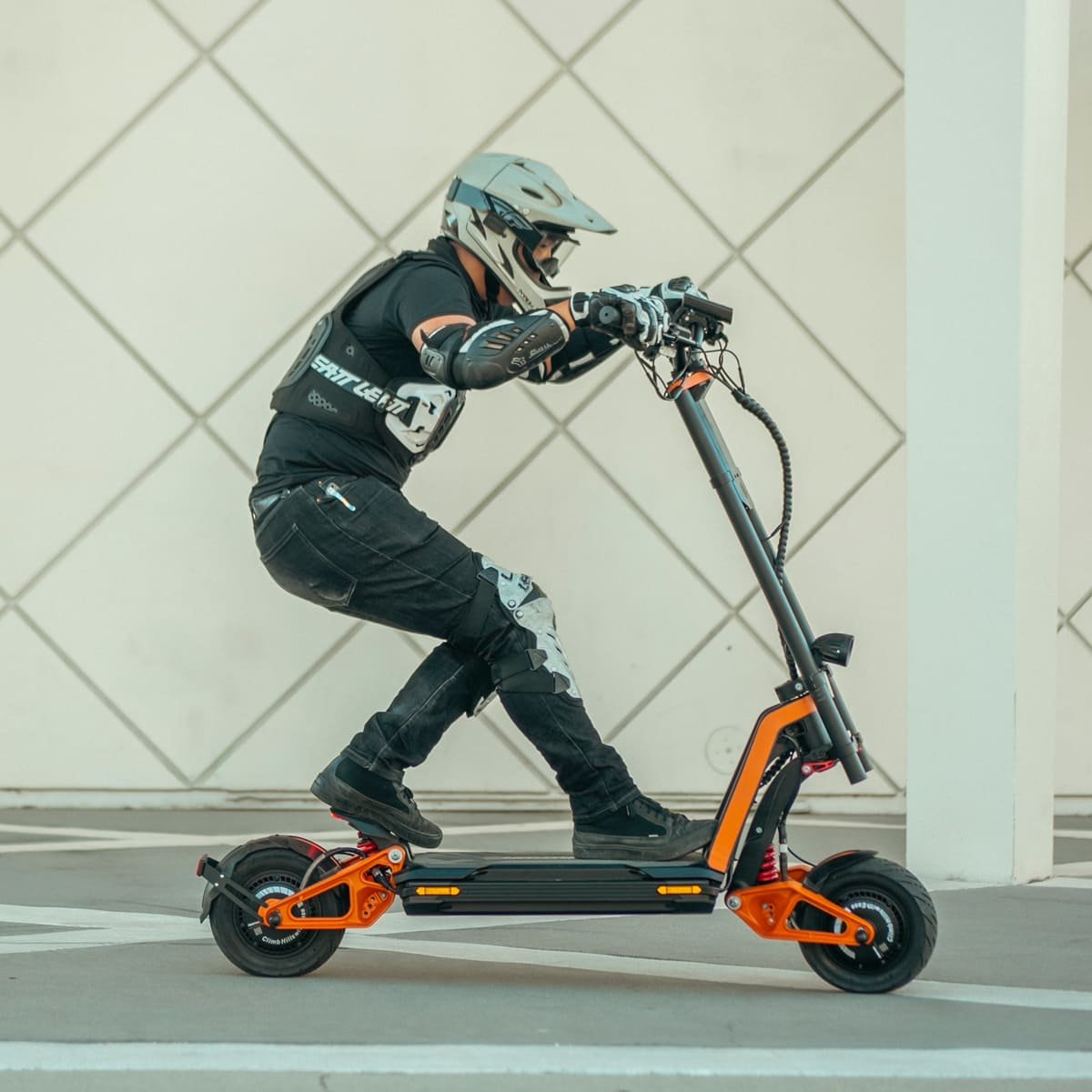 Rider leaning hard on an INMOTION RS Lite electric scooter beside a tiled wall
