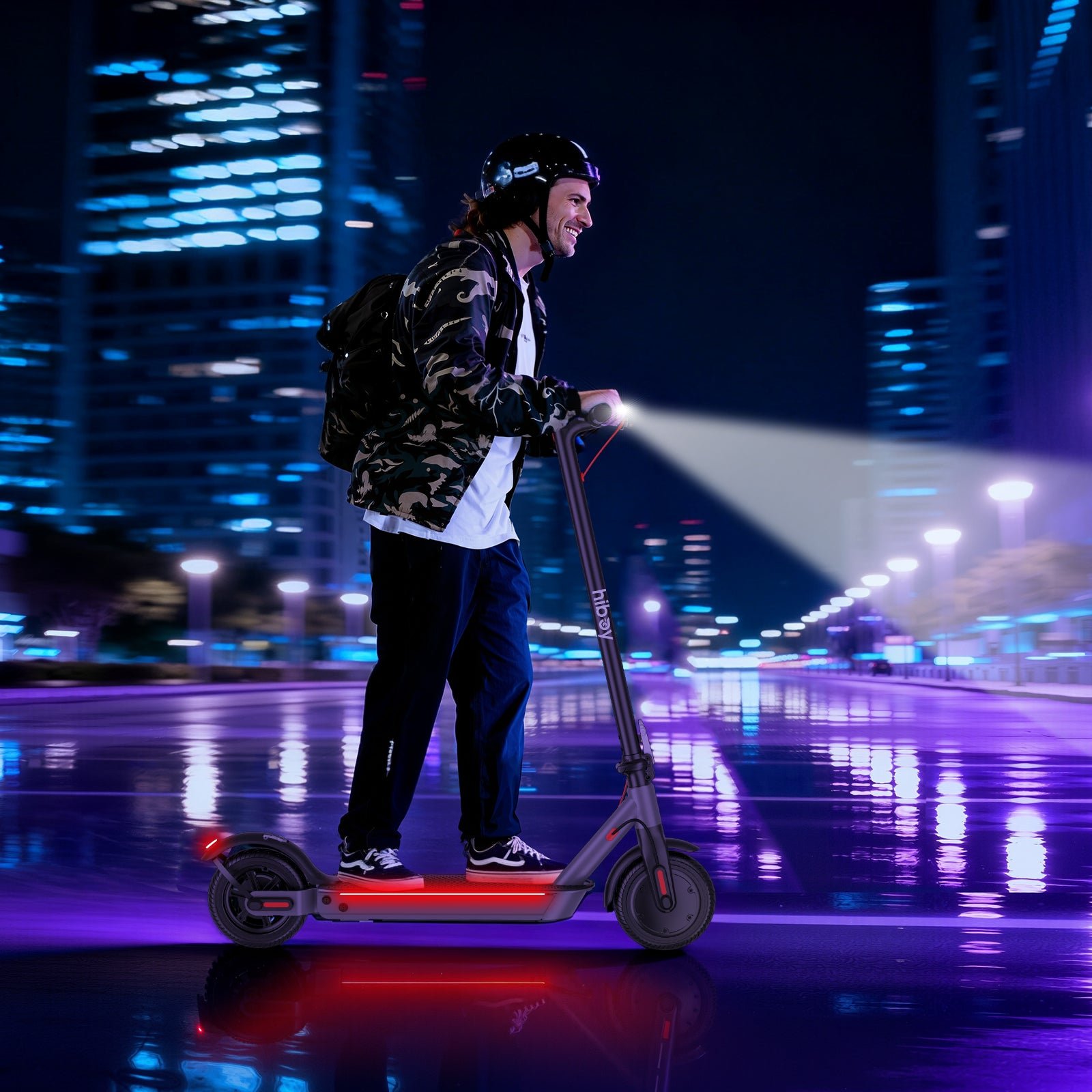 Rider on the Hiboy S2 Nova electric scooter at night with the deck lights glowing red