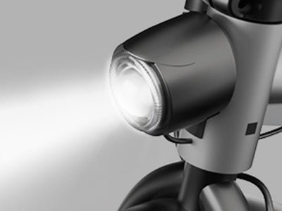 Headlight of the Hiboy VE1 Pro electric scooter lit against a grey background