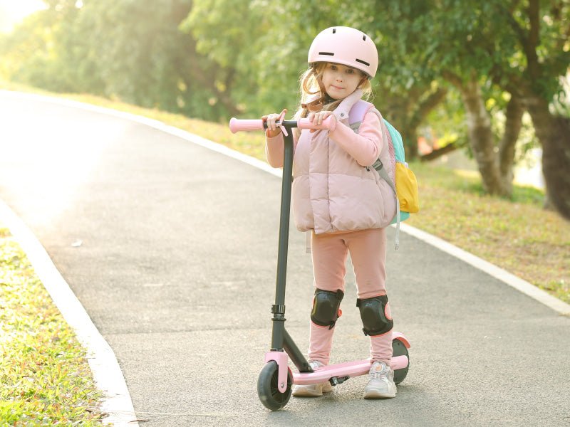 Child with a backpack standing beside a pink Hiboy ES1 kids electric scooter