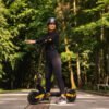 Rider on the Teverun Blade Mini Ultra electric scooter on a forest path