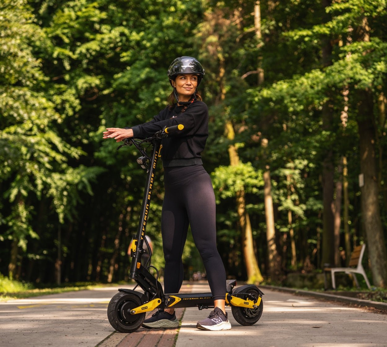 Rider on the Teverun Blade Mini Ultra electric scooter on a forest path