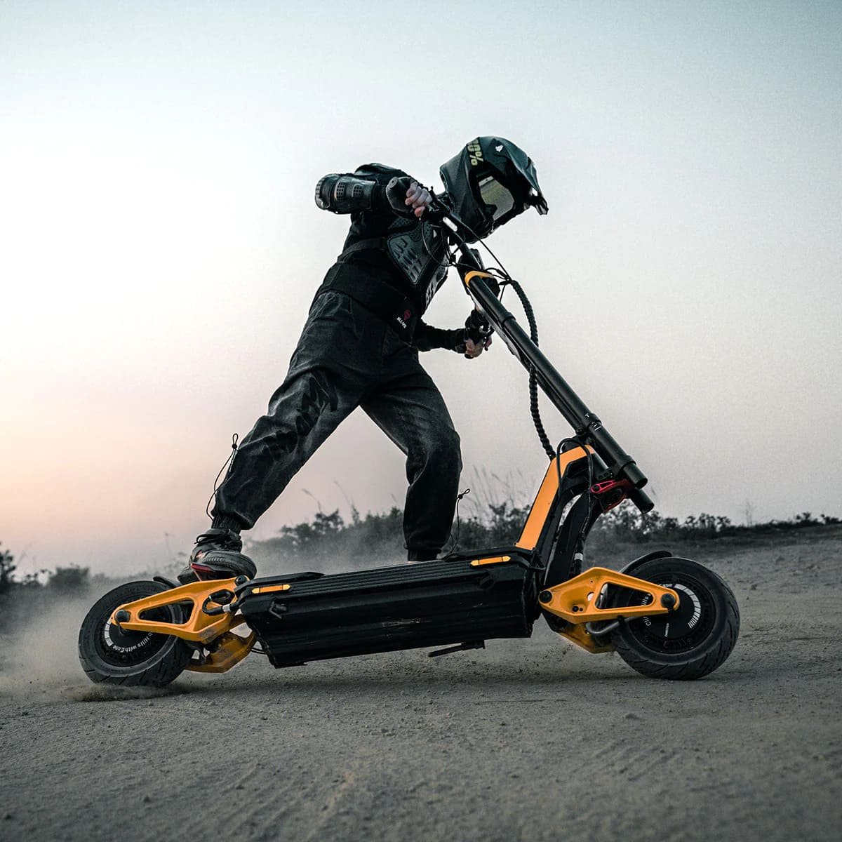 Rider leaning an INMOTION RS electric scooter through loose dirt at dusk