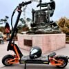 INMOTION RS Lite electric scooter parked in a plaza with a helmet resting on the deck