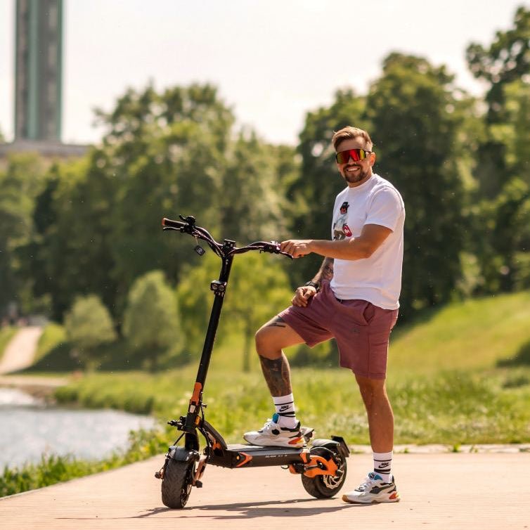 Rider standing with the Teverun Blade GT II electric scooter on the waterfront