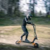 Rider on an INMOTION RS electric scooter moving fast along a woodland trail