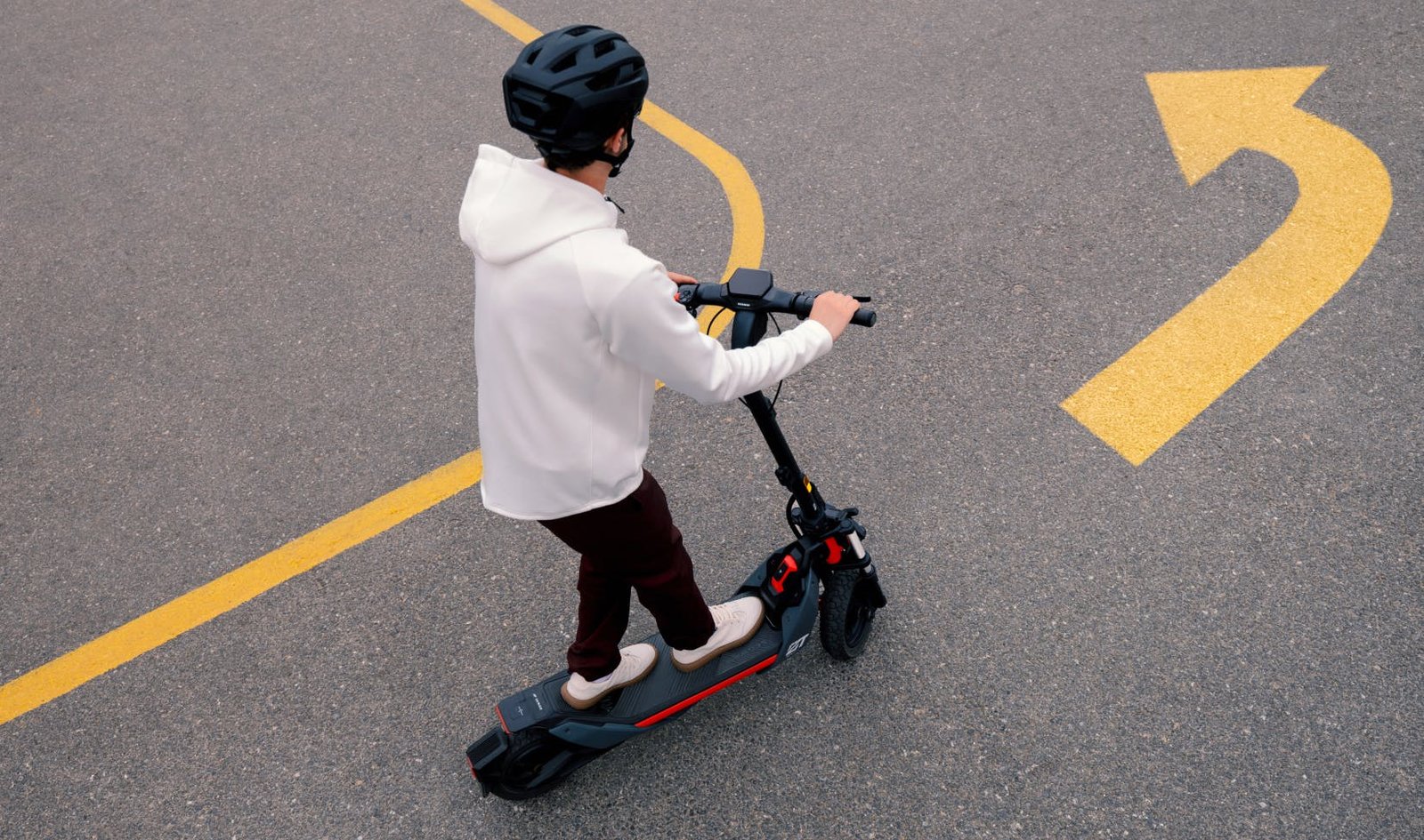 Rider turning the Segway ZT3 Pro electric scooter on a marked road