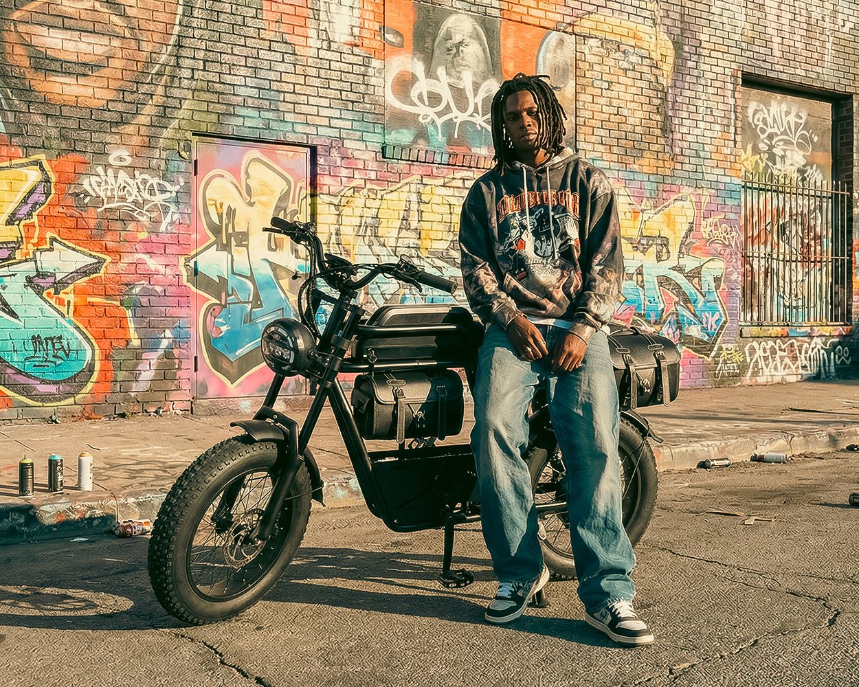 Rider seated on the Riding’times GT33 cargo electric bike beside a graffiti wall
