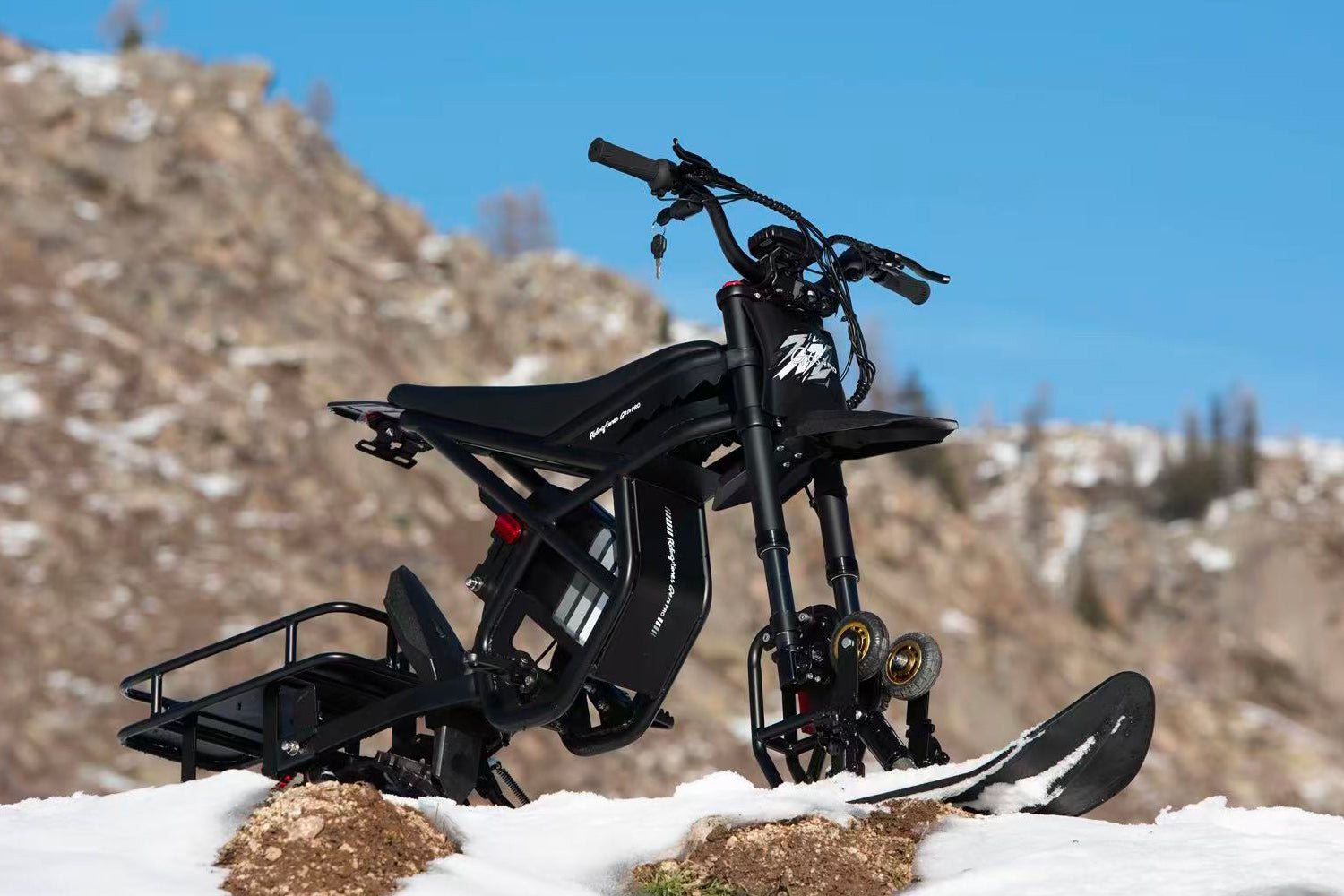 Riding’times GT electric motorbike fitted with the snow track kit parked on a snowy ridge