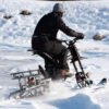 Rider crossing a frozen field on a Riding’times electric motorbike with the snow track kit