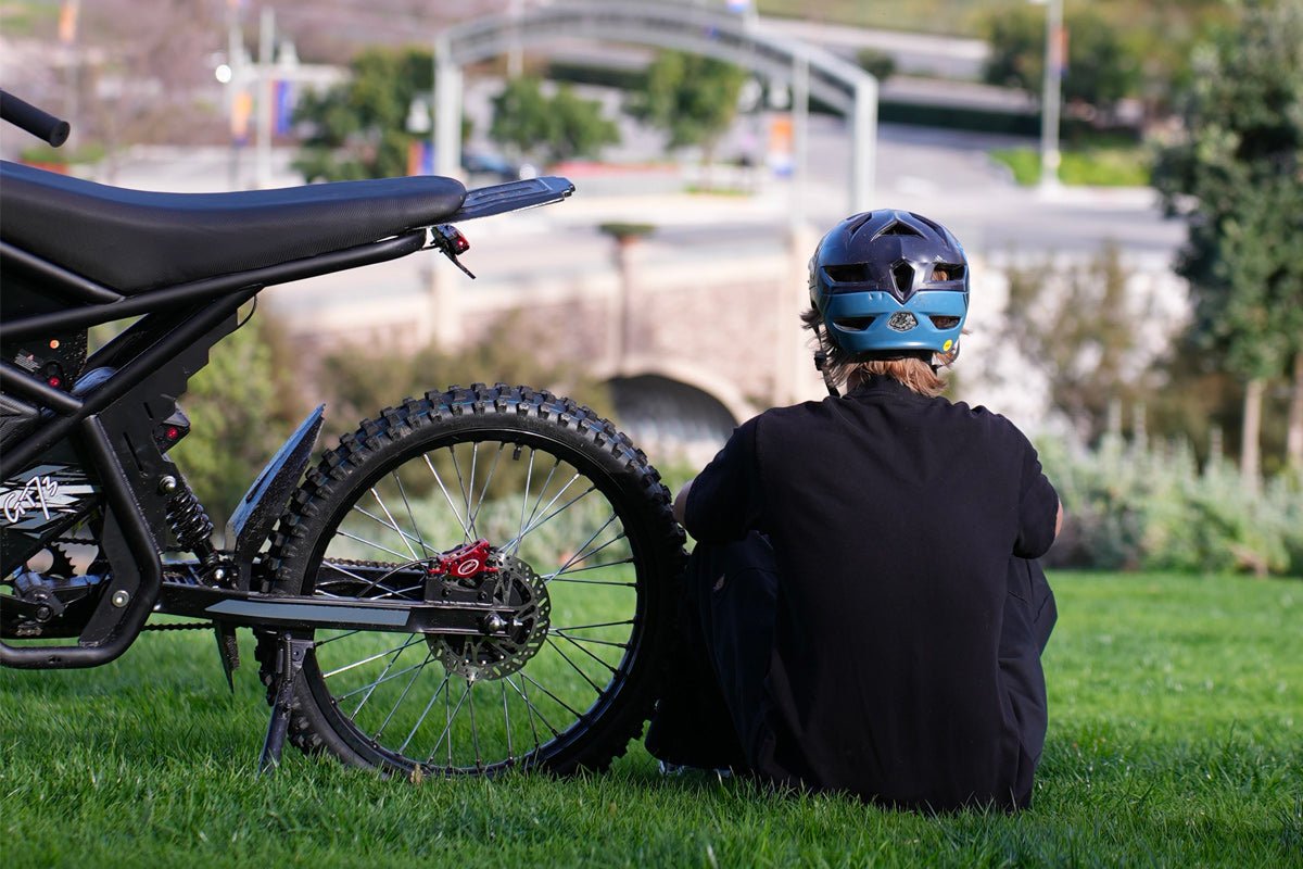 Rider resting beside the Riding’times GT73 electric motorbike in a park