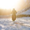 Rider heading into low winter sun on a Riding’times electric motorbike with the snow track kit