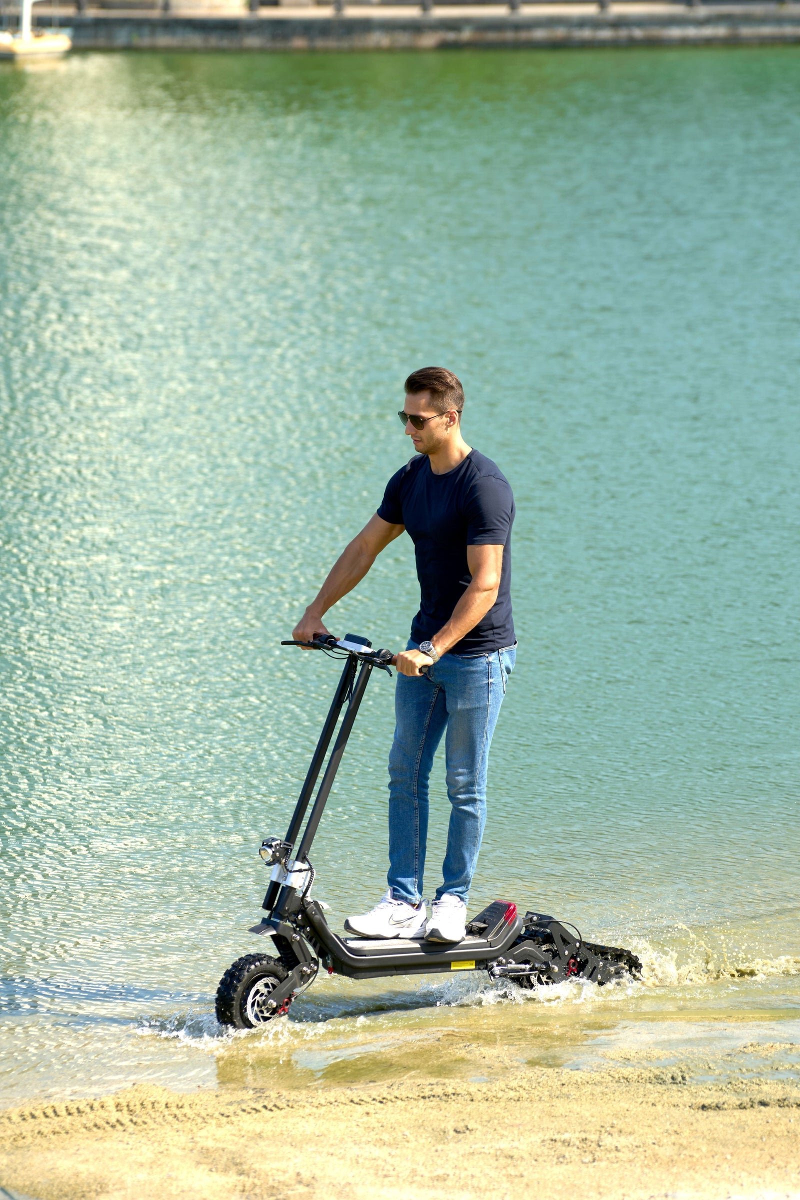 Rider on the Riding’times G63 Convertible electric scooter at the water's edge on a beach