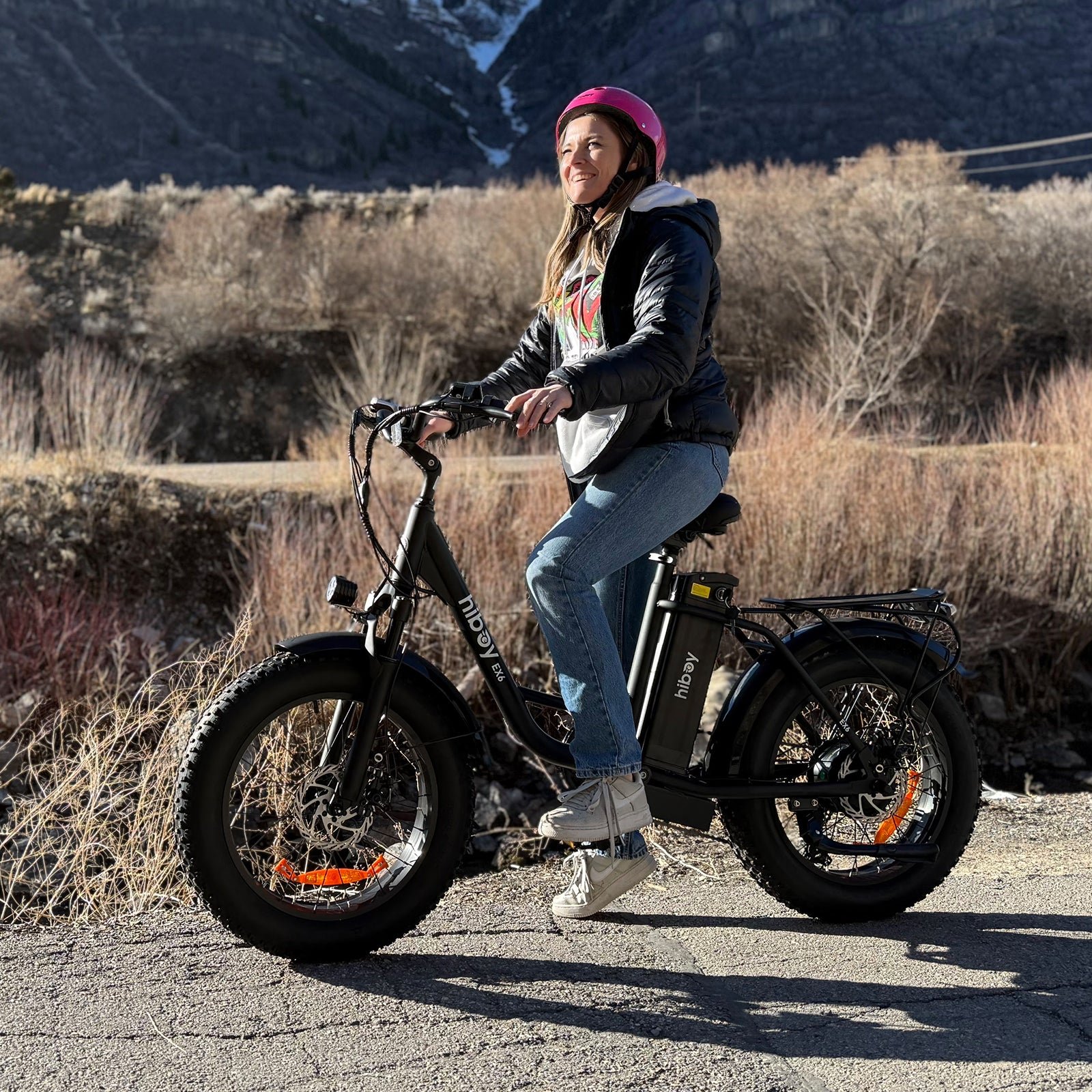 Rider in a pink helmet on the Hiboy EX6 electric bike on a mountain road