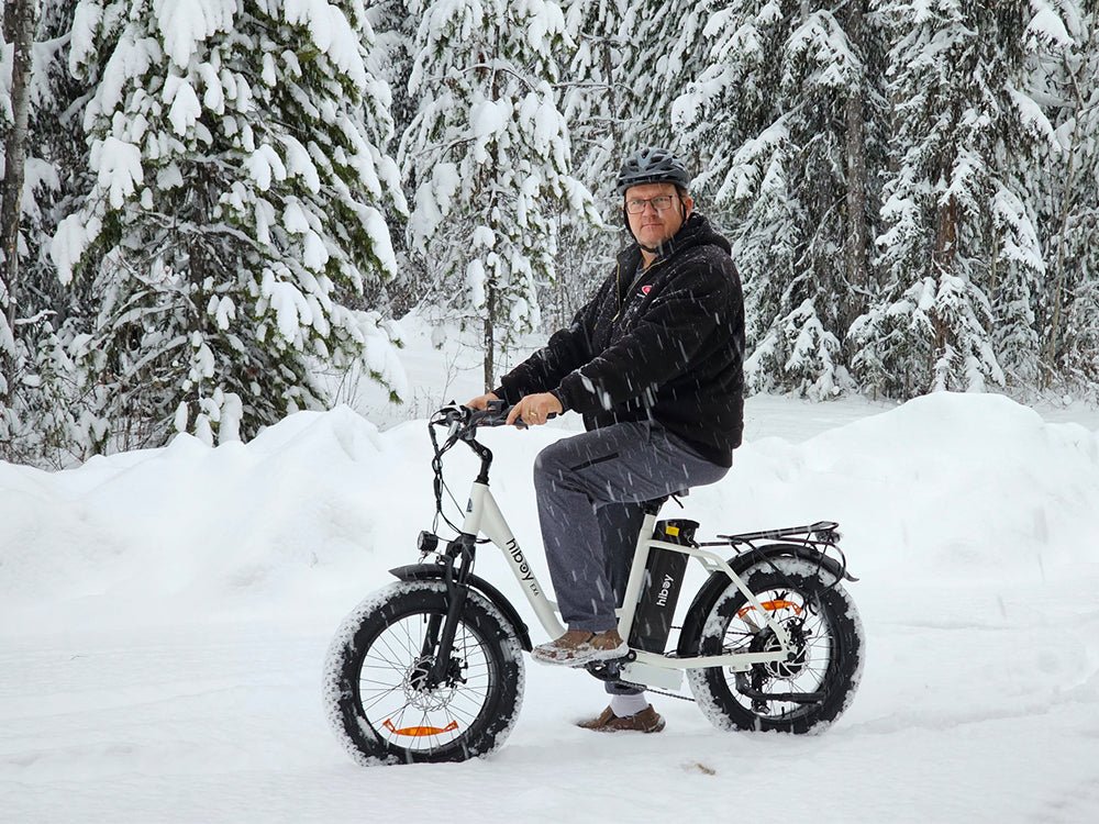 Rider on a white Hiboy EX6 electric bike in a snowy forest