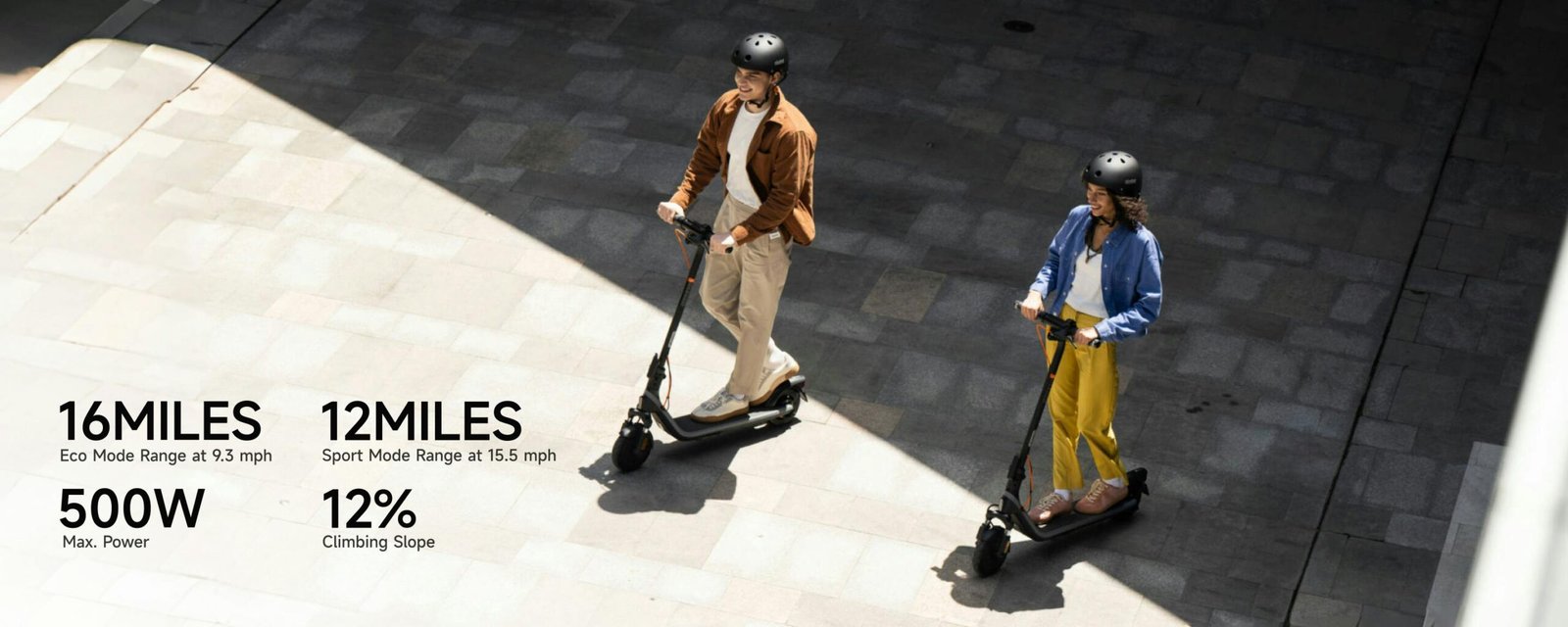 Two riders on Segway E2 Plus II electric scooters with range and power callouts: 16 miles Eco, 12 miles Sport, 500W, 12 percent slope