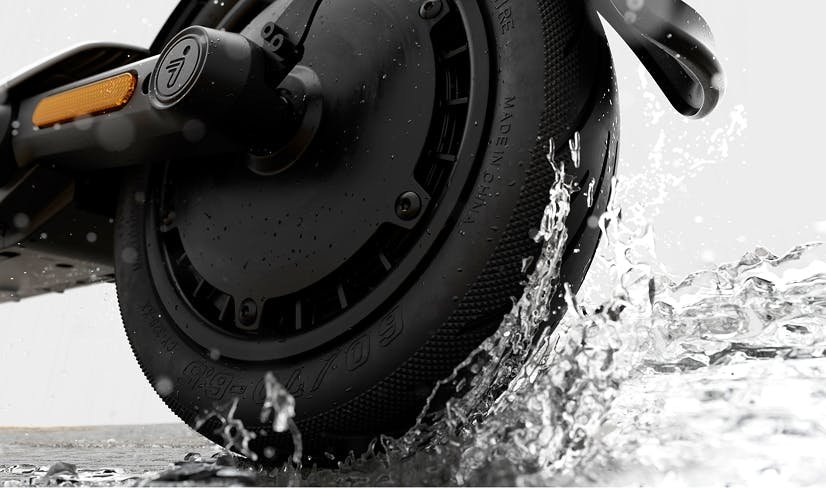 Rear wheel of the Segway E3 Pro electric scooter splashing through water