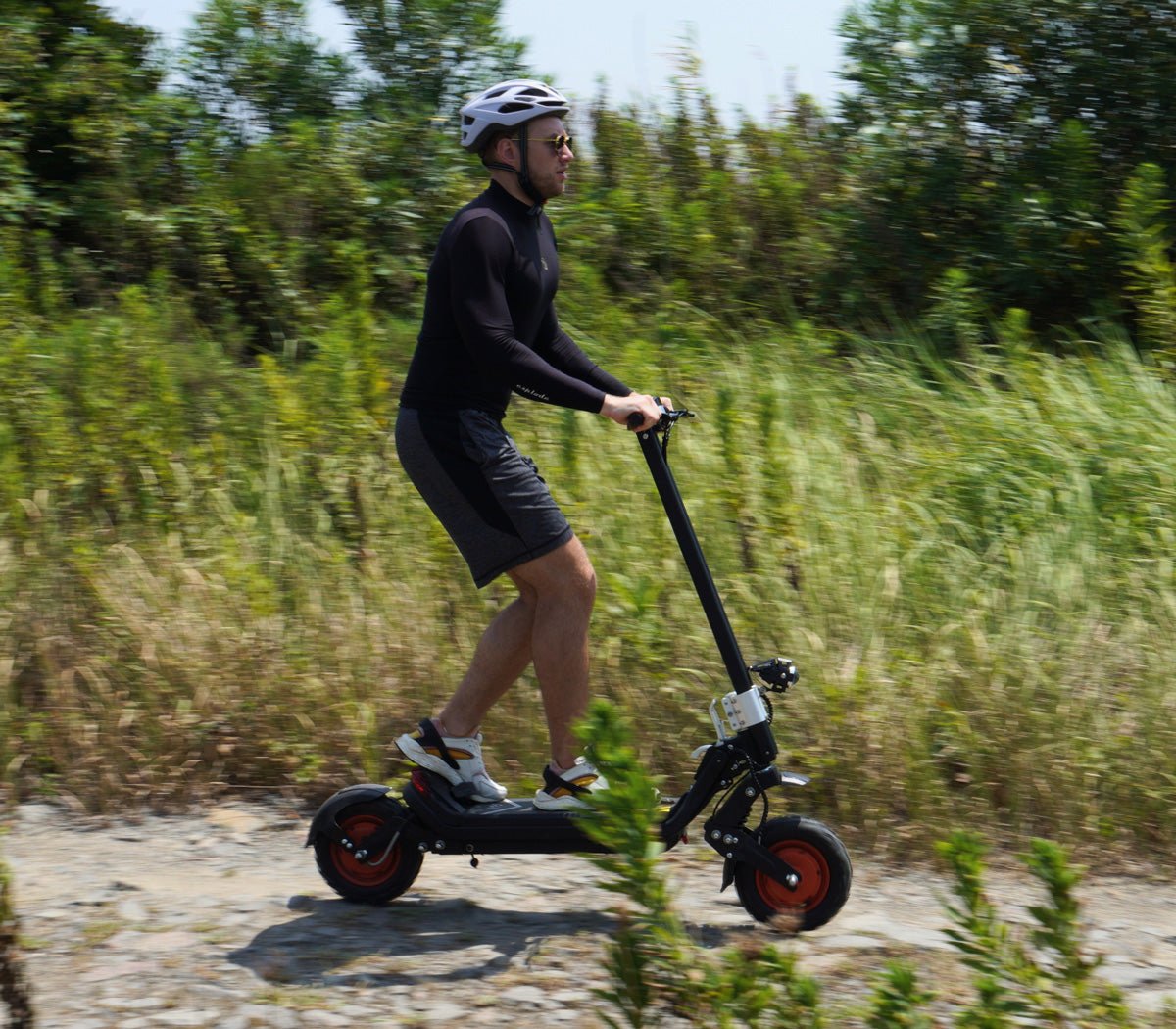 Rider on the Riding’times G63 dual motor electric scooter on a country road