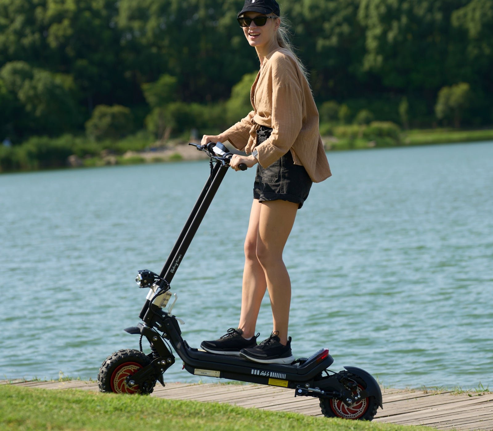 Rider on the Riding’times G63 dual motor electric scooter beside a lake