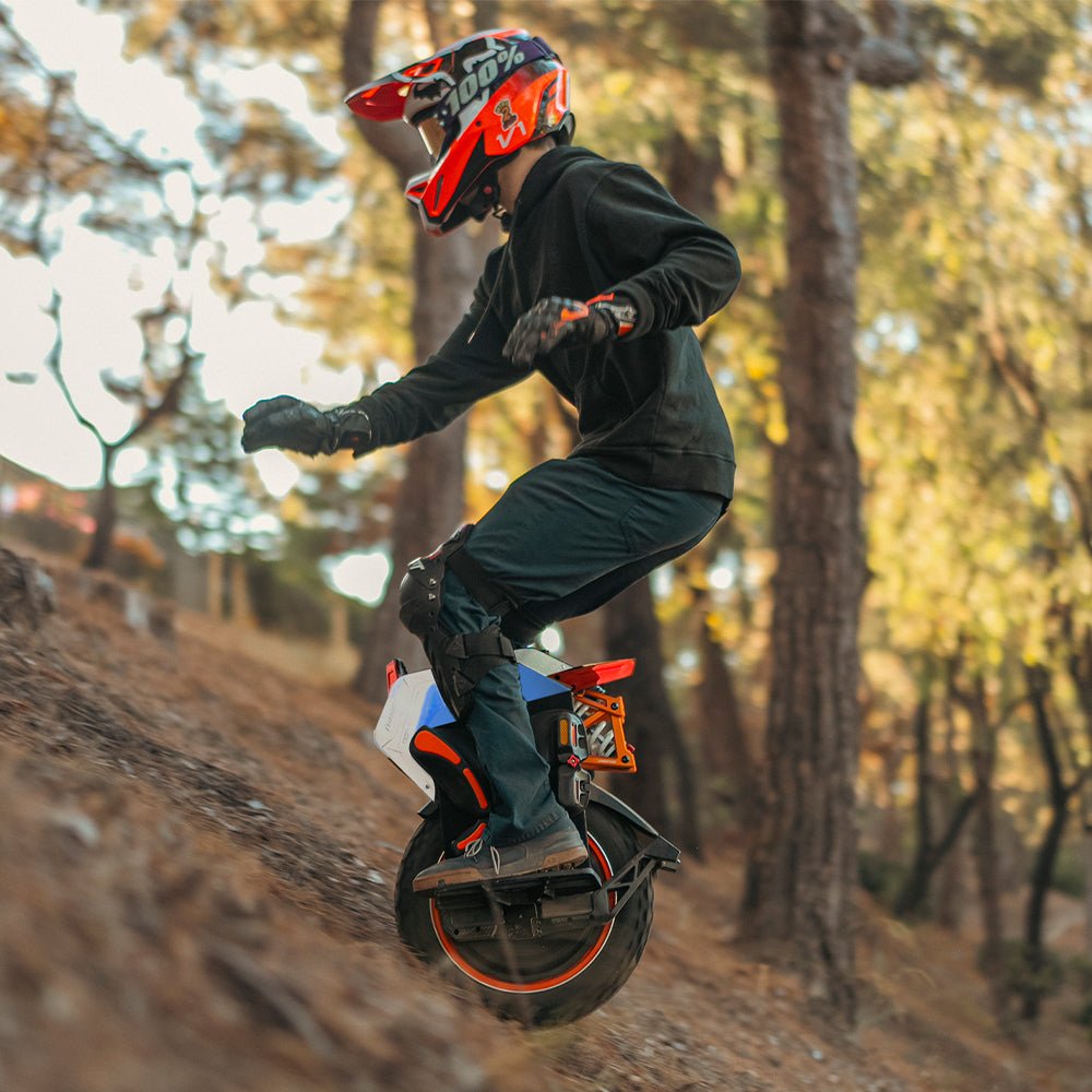 Rider on an INMOTION V14 PRO electric unicycle dropping down a forest slope