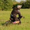 Rider crouched beside the Riding’times Z8 Pro electric bike in a meadow