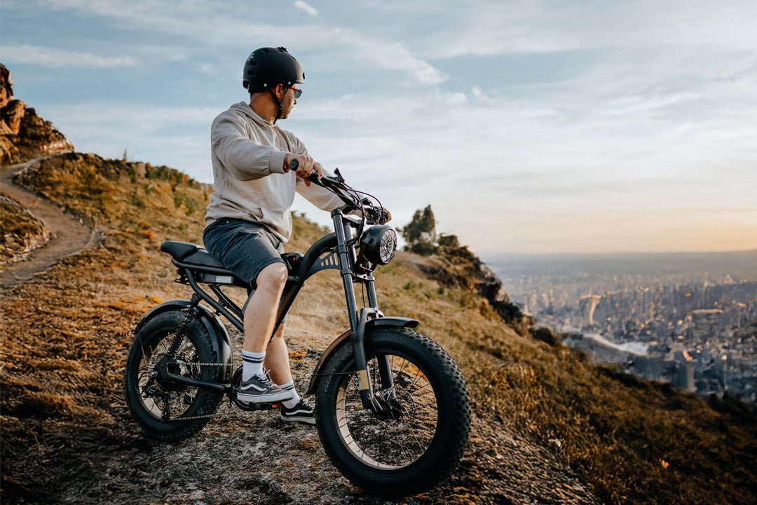 Rider standing with the Riding’times Z8 Pro electric bike on a hilltop above a city