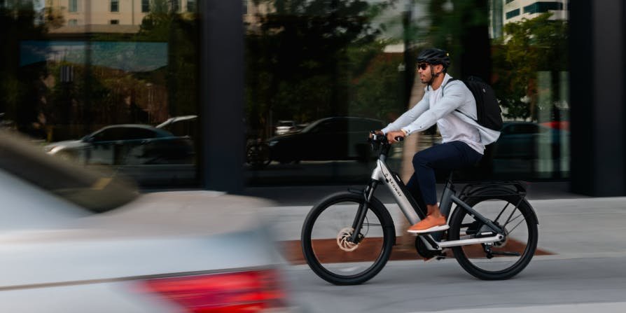 Rider accelerating past a storefront on the Segway Myon electric bike