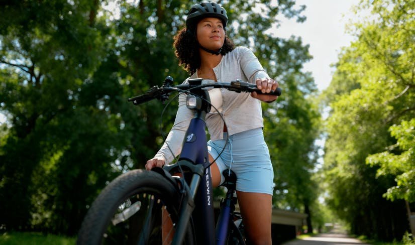 Rider on the Segway Myon electric bike on a tree-lined path